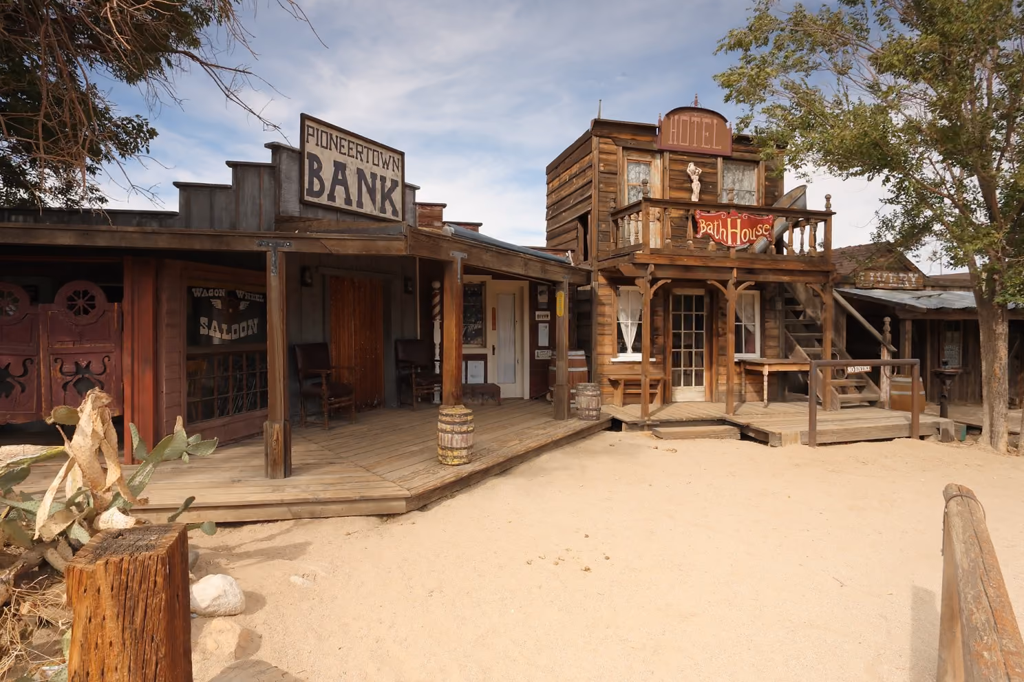 Weathered wooden storefronts (saloon, bank, bath house, and livery stable) lining Mane Street in Pioneertown, California.